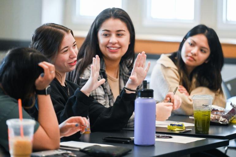 四个年轻女子在大学教室里交谈.